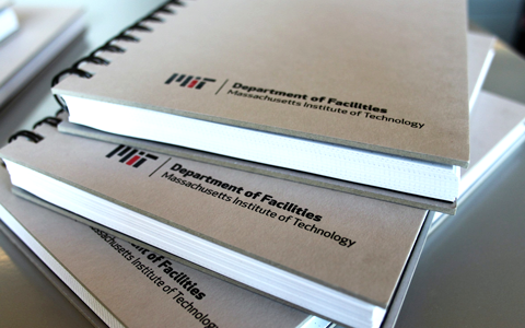 The Facilities logo is shown on a stack of booklets with spiral binding.