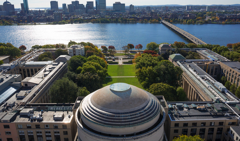 Aerial photo of the MIT Dome in the foreground, with Killian Court and the Charles River in the background.